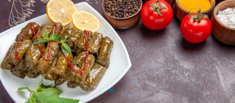 front-view-delicious-leaf-dolma-with-seasonings-tomatoes-dark-space